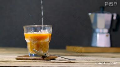 Pouring cream in a glass with iced coffee